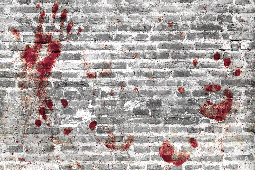 Bloody handprints and blotches of blood on grunge wall. Background for spooky content, halloween and more.