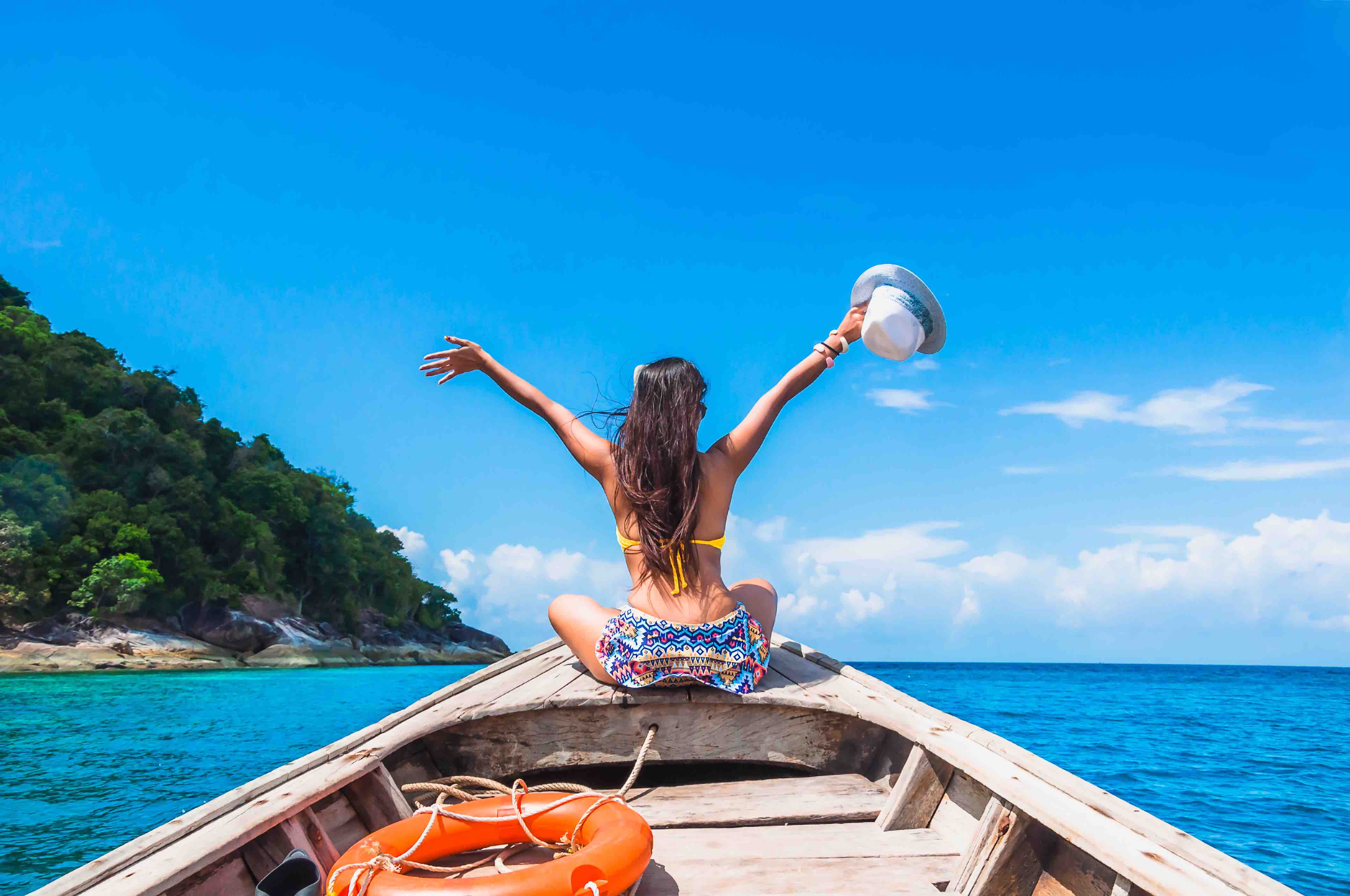 Happy woman traveler in bikini relaxing on boat her arms open feeling freedom, Andaman sea, Surin island, Phangnga,Travel in Thailand, Beautiful destination Asia, Summer holiday outdoors vacation trip